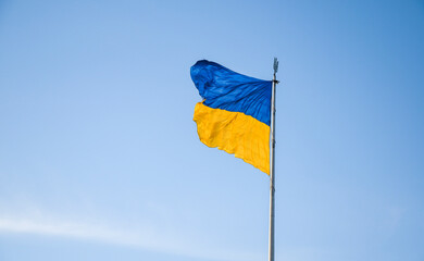 Blue and yellow Ukrainian flag waving in clear sky background
