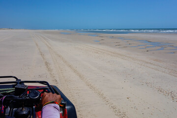 Fototapeta na wymiar driver POV of ATV quadricycle on the beach in the Brazilian coast, sunny day