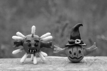 Fototapeta na wymiar A close-up figure of a virus and a pumpkin made of plasticine. The concept of Halloween.