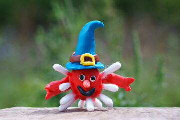 A plasticine virus figurine in a festive hat. The concept of Halloween.