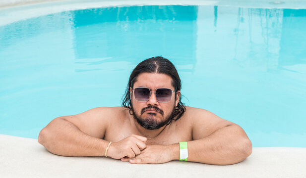 A displeased man in his 30s at the swimming pool. Possible negative review. - Powered by Adobe