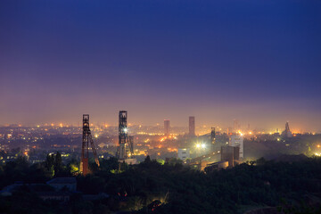 Industrial area with a large number of mines for underground mining of ore or coal. Night view of the towers of the mine shafts.