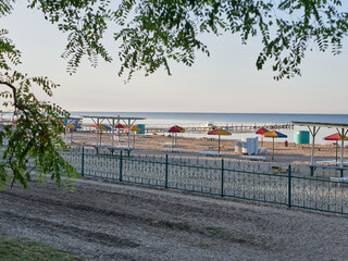 Sunbeds and umbrellas on the beach are waiting for vacationers. Summer vacation at sea.