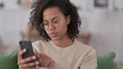 Young African Woman using Smartphone at Home