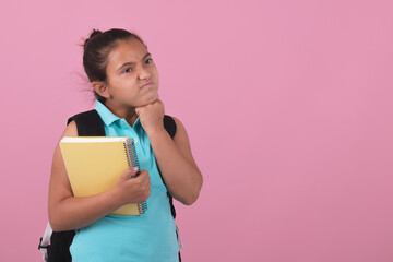 School girl holding notebook and carrying backpack with angry expression