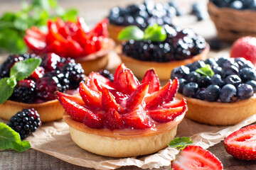 Fresh homemade berry tarts with strawberries, blueberries, blackberries with fresh berries.