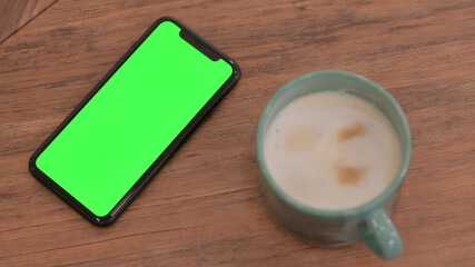 Smartphone with Chroma Screen on Table next to Coffee