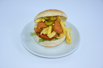 nugget sandwich with french fries, lettuce, tomato, pickled cucumber