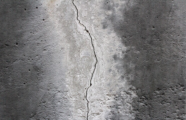 Vertical crack in a concrete gray wall