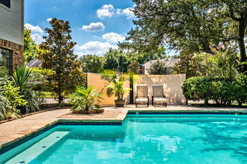 Backyard oasis with a swimming pool inside a private residential backyard. - 453363267