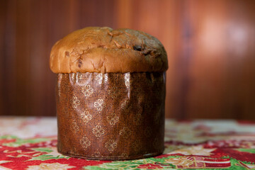 Panettone on the table with a Christmas tablecloth. Panettone concept. Christmas concept. copy...