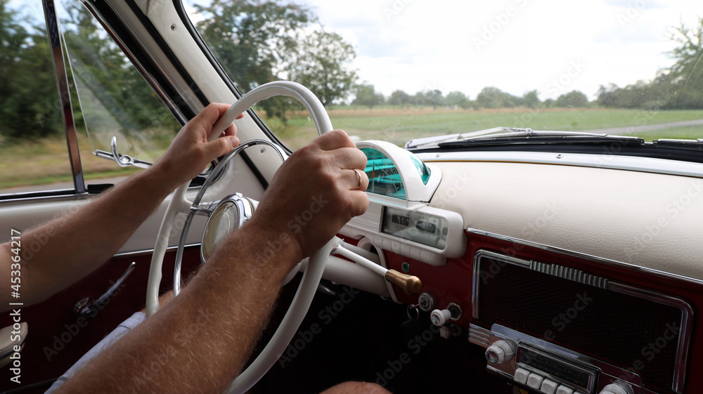 Sticker man driving a vintage car captured f the inside