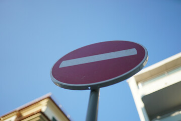 Low angle of a red do not enter sign on the street against the blue sky