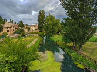 Fototapeta na wymiar View of clear river in the medieval center of Bevagna little town in the green umbria, Italy