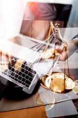 Justice and law concept.Male judge in a courtroom with the gavel, working with, computer and docking keyboard, eyeglasses, on table in morning light
