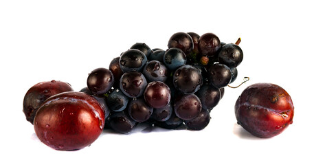 Close-up bunch of ripe red small grapes and large red plums isolated on white. Isolated fruit and berry set for making juice, compote or wine.