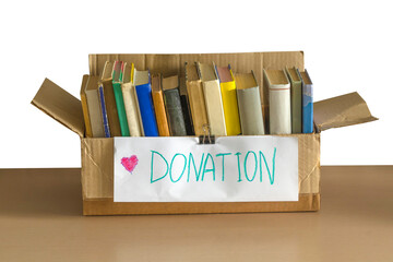 Cardboard donation box full of books. Donation concept. Help for children, support for poor kid. Social care, volunteering and charity concept. Donation box book.