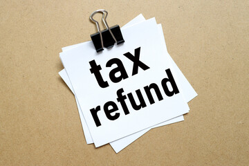 Tax Refund, the paper is clamped with a clerical clip. paper on wood background.