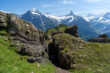 Fototapeta na wymiar des blocs rocheux au milieu d'un paysage montagneux avec des sommets enneigées en arrière plan