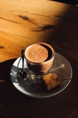 Foto op Canvas hot drinking chocolate in cafe glass with toasted marshmallow on the side with spoon sunlight © Nicole Kandi