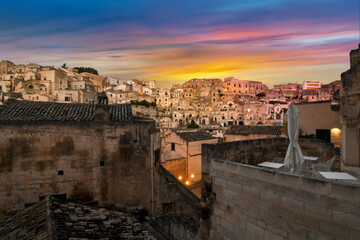 Fototapeta na wymiar A colorful sunset over the ancient sassi and dwellings in the town of Matera, Italy, in the Basilicata region.