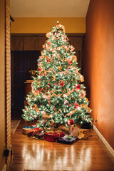 faux fake green Christmas tree in gold room with presents 