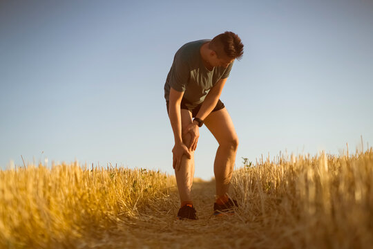 A young man jogging at sunset.