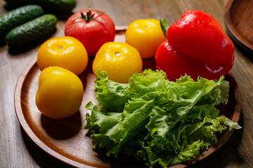lettuce, yellow and red tomatoes and bell pepper with water drops. cucumbers.