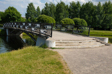 Summer landscape. Bridge over a river or body of water in a park on a summer day.