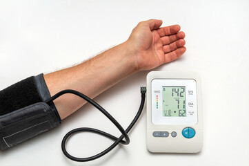 The person measures their own blood pressure at the medical table. Taking care of your own health....