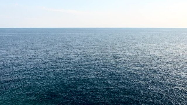 Blue sea and blue sky on horizon. Calm sea surface at summer. Seascape.