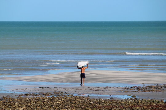 Jijoca from Jericoacoara, Ceará, Brazil. June 10, 2018. Surfer going into the sea. - Powered by Adobe