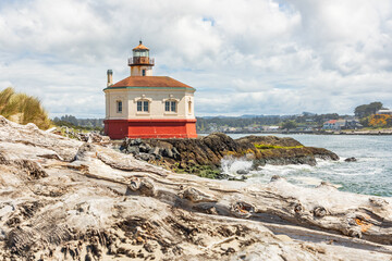 Beach logs and the Coquille River Lighthouse on the Oregon coast.