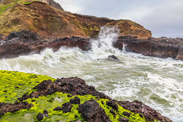 Fototapeta na wymiar Surf crashing on rocky shore on the Oregon coast.