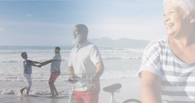 Composite of happy diverse senior couple walking with bikes,and dancing on beach