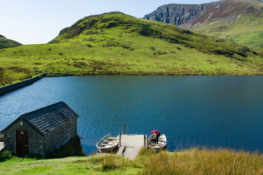 Beautiful mountain landscape, Snowdonia, Wales. High angle view of lake Dywarchen high in the hills of the Snowdon peaks. Dramatic scene on a summers day. Blue sky and copy space.