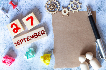Gift box and wooden calendar with trendy blue numbers, September 27, business planner.
