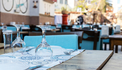 A table arranged inside the restaurant. Wine glasses and cutlery.