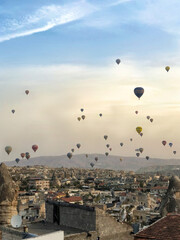 Hot air balloons flying in the sky at sunrise in Cappadocia, Turkey.
