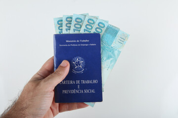 Bahia, Brazil. August 27, 2021. Brazilian work card and Brazilian money. TRANSLATION: Federative Republic of Brazil, Ministry of Labor. Work record booklet and Social Welfare.