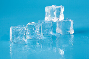 Five cubes of melting ice on a blue background