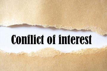 Conflict of interest written under torn paper on the white background
