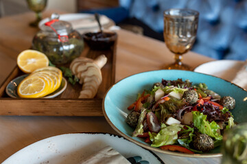 Cooked spinach and garlic salad on a blue plate. Lemon and ginger on a grilled plate Vegetarian food 