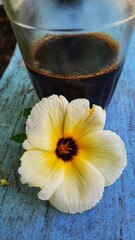 a flower lay on the table beside a cup of coffee in the morning. soft focus