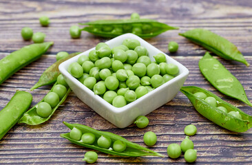 Chicharos frescos (leguminosas). Granos verdes frescos en recipiente blanco.
