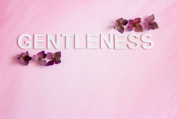 The word, GENTLENESS, spelled in capital letters written horizontally with hydrangea flowers; the...