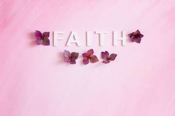 The word, FAITH, spelled in capital letters written horizontally with hydrangea flowers; the word, FAITH, placed on a pink painterly background with room for text