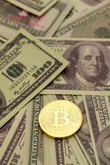 Golden coin with crypto currency sign and symbol on pile of dollar banknote. Idea for blockchain, the new type of money in the economy of the business world