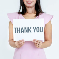 Studio shot of unrecognizable unidentified faceless female officer in business clothes holding thank you paper sign at chest showing appreciation to customers and colleagues on white background