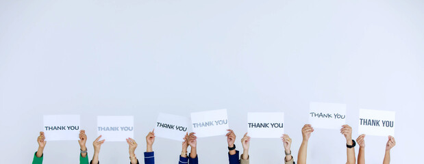 Studio shot of variety fonts thank you letters paper sign holden above head by group of...